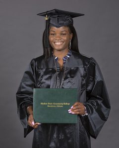 Shelton State Adult Education Student Gloria Adingni holds her college diploma.